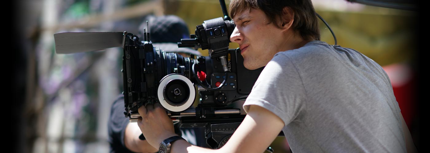 NYFA Student looks through a camera at a film set